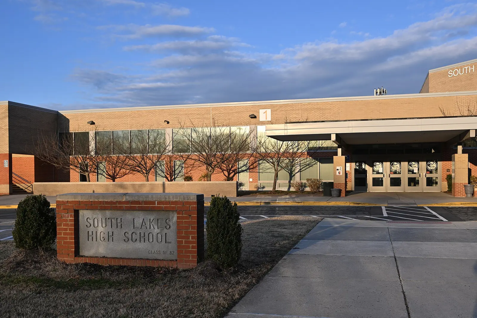 The South Lakes High School sign and the front entrance of the school on South Lakes Drive in Reston, early on a spring morning