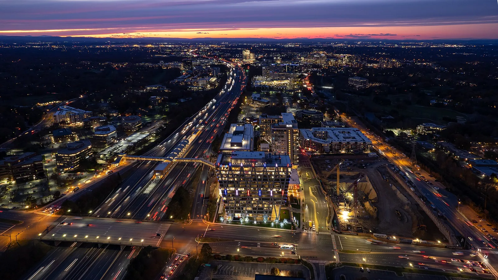 Reston Station, the Wiehle-Reston East Metro station and the Dulles Toll Road at dusk, with Reston Town Center on the horizon.